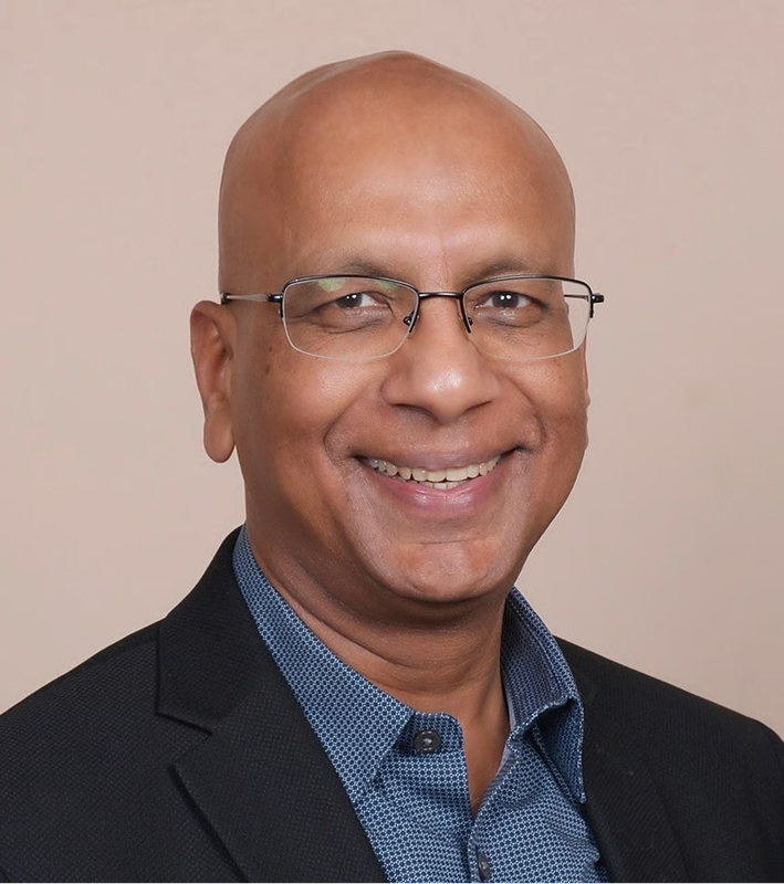 Anil Gupta, a leader at Censys, is smiling in a professional headshot wearing glasses, a dark blazer, and a blue shirt.