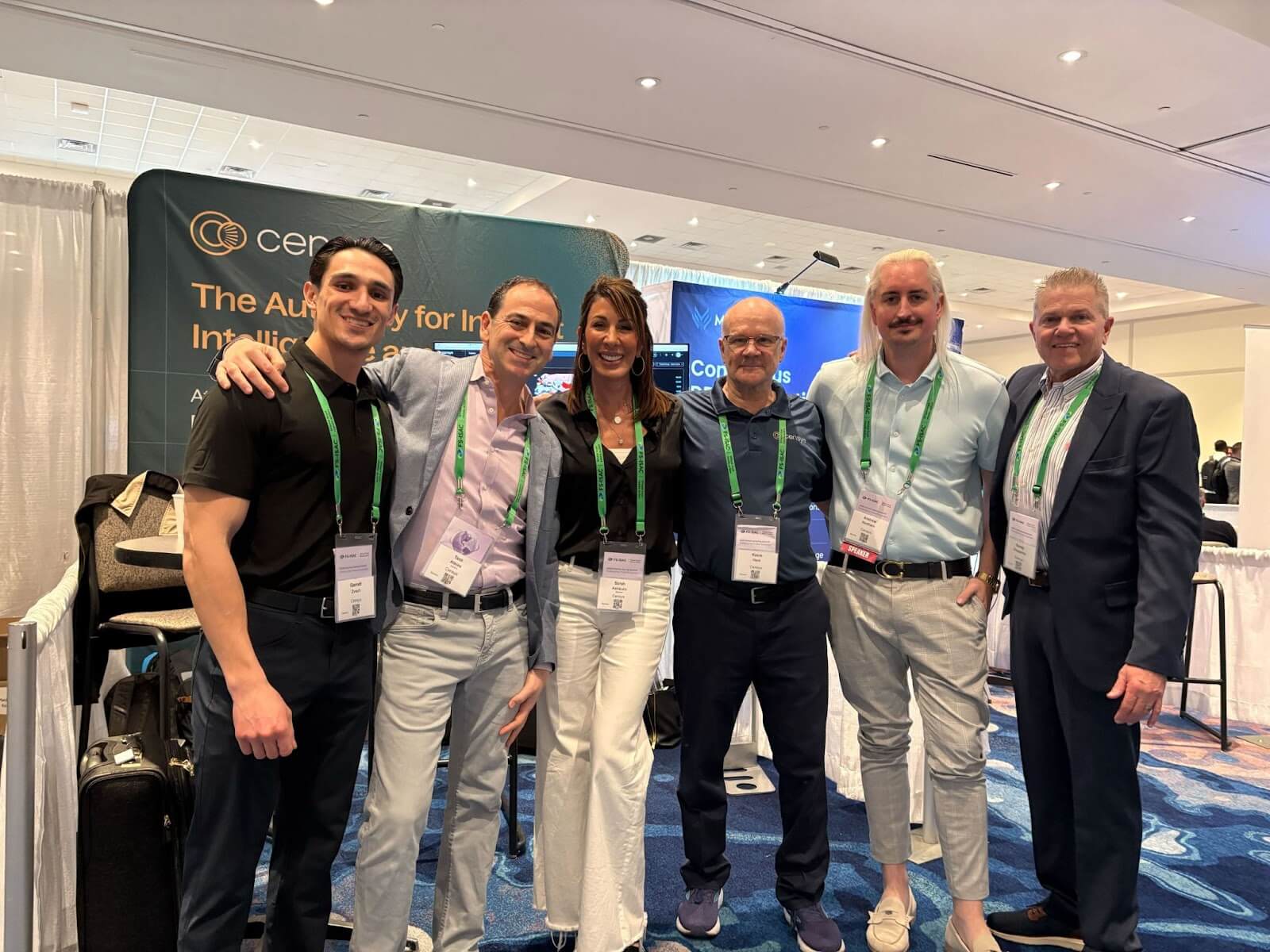 Six Censys team members wearing conference lanyards pose together smiling in front of the Censys booth at an industry event.