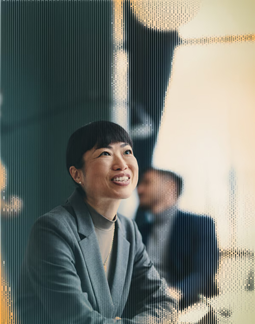 Censys Partners Unlock Opportunities with Censys A smiling woman in a gray blazer engages in a professional conversation in a modern office setting.