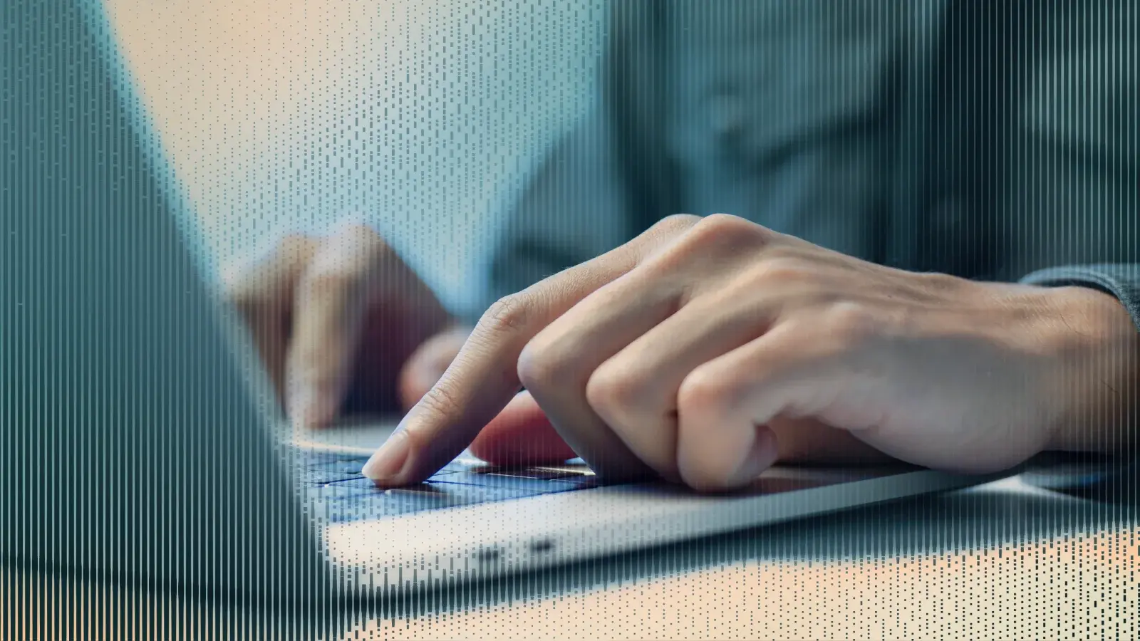 Hands typing on a laptop